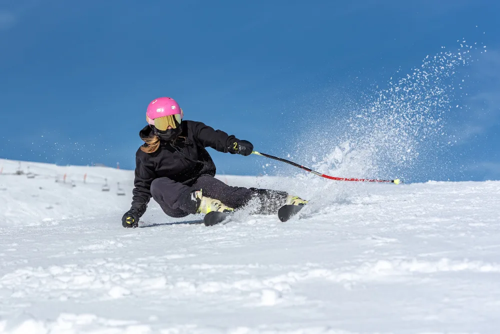 Skier carrying equipment at a snowy mountain resort